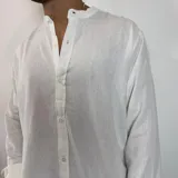 Camisa de manga larga con cuello mao, confeccionada en lino, con corte regular y cierre frontal de botones.