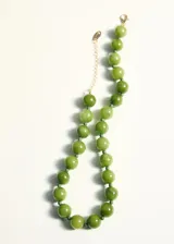 Collar de cuentas esféricas de piedra en tono verde, con cierre de mosquetón y cadena de alargue metálica en color dorado.