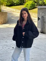 Campera negra con botones, de corte holgado y mangas abullonadas.