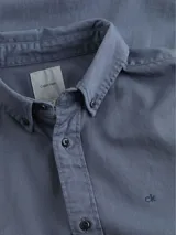 Camisa de manga larga Calvin Klein, confeccionada en sarga de algodón. Presenta cuello abotonado, cierre frontal con botones y logo de la marca bordado en el pecho.