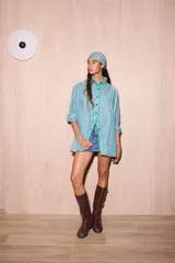 Camisa de popelina a rayas rosadas, marrones y azules, de corte holgado y relajado, con mangas largas y una distintiva abertura frontal con bordes ribeteados.