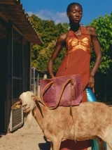 Vestido midi con pechera de cuero metalizado dorado y falda tejida en punto con destellos de lurex. Presenta un diseño de cuello halter con tiras finas y una abertura lateral en la falda.