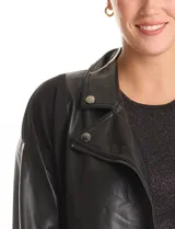 Campera estilo biker confeccionada en cuero sintético con paneles de neopreno en los laterales. Presenta cuello con solapas, cierre frontal cruzado, bolsillos inclinados y mangas largas con cierre metálico en los puños.