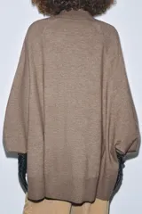 Jersey de punto oversize con cuello subido y mangas largas con diseño holgado.
