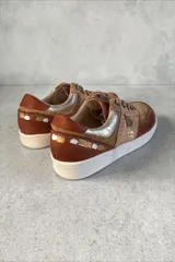 Championes de cuero en tonos marrones y beige combinados, con texturas y detalles pintados a mano por Carolina De Cunto, suela de goma blanca y cordones marrones.