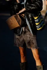 Short de jean gris oscuro con efecto desgastado y roturas, tiro alto y ruedo desflecado.