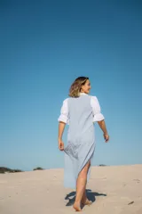 Vestido camisero largo celeste con cuello y mangas cortas abullonadas blancas.