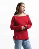 Buzo de lana merino con cuello bote, manga larga y diseño holgado. Presenta un pequeño detalle bordado a mano en la parte inferior frontal.