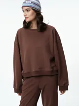 Buzo de cuello redondo y manga larga, con diseño oversize y corte relajado. Presenta puños y ruedo acanalados, confeccionado en tejido de textura suave.