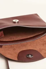 Cartera tipo sobre de cuero color marrón, con solapa frontal redondeada que presenta un detalle circular grabado. Incluye correa larga ajustable y extraíble, cierre principal y broche de seguridad.