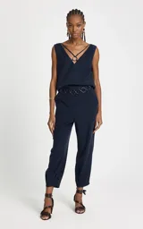 Pantalón sastrero de corte recto en color azul marino, con cintura media y detalle de cinturón de cadena metálica extraíble. Presenta un largo crop y acabado pespunteado.