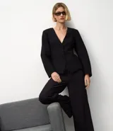 Pantalón de vestir azul marino, de corte amplio, con cintura alta, cinturón incorporado y cierre delantero.