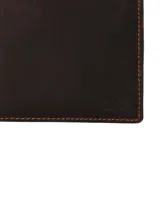 Billetera plegable de cuero natural engrasado color marrón, con costuras pespunteadas a contratono y tecnología RFID de protección antirrobo.