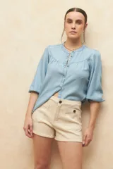 Short de jean color beige, de tiro alto y corte ajustado, con cuatro bolsillos y cierre frontal con botón.