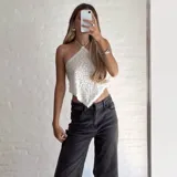 Top blanco con textura, escote halter y espalda descubierta.