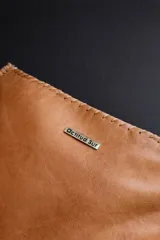 Sobre de mano confeccionado en cuero con pelo natural con estampado animal print en tonos blanco y negro, con cierre superior.