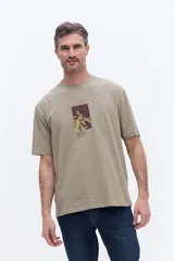 Remera de manga corta color beige, con cuello redondo y estampa gráfica central con motivos botánicos y texto.