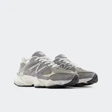 Championes urbanos New Balance modelo 9060, color gris con detalles en verde y blanco, confeccionados en gamuza y malla, con logo "N" característico en los laterales y entresuela con amortiguación ABZORB y SBS.