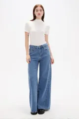 Pantalon de jean negro de corte ancho y tiro alto, con cierre frontal y bolsillos laterales.