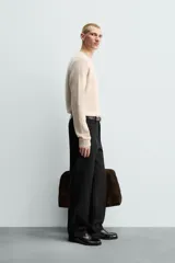 Jersey de punto canalé con cuello redondo y manga larga, confeccionado en hilatura de cashmere. Presenta un corte regular fit con acabados en rib en puños y bajo.