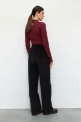 Pantalón de pana color verde oliva, de tiro alto y corte recto. Cuenta con cuatro bolsillos, los delanteros con solapa y botón metálico.