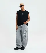 Pantalón de jeans para hombre, modelo super baggy, color celeste desgastado, con estampa de grafiti en negro en ambas piernas. Presenta cintura con trabilla, cierre tradicional y bolsillos.