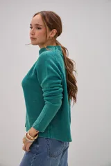 Sweater de tejido de punto en color verde, con cuello alto tipo mock neck y mangas largas con costuras raglán. Presenta un diseño de textura granulada y corte recto.