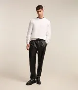 Suéter negro de tejido de punto maquinetado con cuello redondo y manga larga.