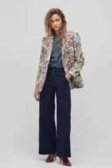 Blazer de poliéster con estampado floral, corte boxy, bolsillos frontales y cierre de un botón. Las mangas largas tienen un forro de algodón a rayas que se puede lucir al doblarlas.