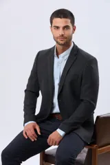 Saco sport de lana en color gris oscuro, con diseño clásico de solapa tradicional, cierre frontal de dos botones y bolsillos laterales con solapa.