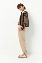 Pantalón de jogging color beige, de corte holgado, con cintura y puños elásticos, y bolsillos laterales.