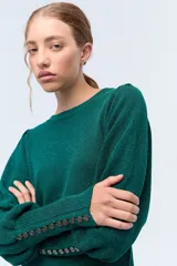 Sweater color crema de tejido de punto con lurex, mangas abullonadas y puños con botones metálicos.