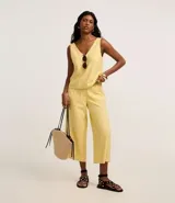 Pantalón pantacourt amarillo de viscosa con lazo en la cintura, cintura elástica y bolsillos delanteros.