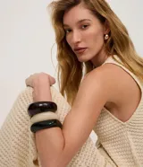 Chaleco de punto color beige claro, con cuello en V y cierre frontal de botones. El tejido presenta un patrón texturizado de pequeños puntos.