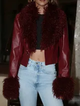 Chaqueta corta de efecto cuero color bordó, con cuello amplio y puños destacados en pelo sintético al tono. Presenta un diseño estructurado con cierre frontal.