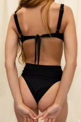 Conjunto de bikini negro con corpiño con aro y bombacha tiro alto semivedetina sin elástico en la cintura.