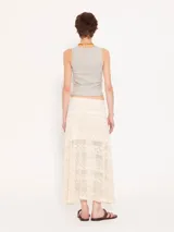 Pollera larga color crudo, confeccionada en tejido calado con lurex, cintura elastizada y forro interno.