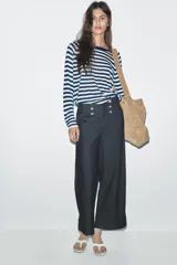 Jersey de punto liso, color azul brillante, con cuello redondo y manga larga. Presenta acabados en rib en puños, cuello y bajo, con aberturas laterales en el ruedo.