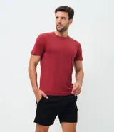Remera deportiva de hombre en color rojo oscuro, con mangas cortas, cuello redondo y detalle de líneas negras en la manga. Confeccionada en poliéster con tecnología dry fit.