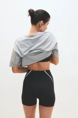 Calza tipo biker de tiro alto, color negro, con costuras laterales decorativas en color blanco. Confeccionada en tejido elástico de alto rendimiento.