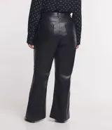 Pantalón flare de tiro alto en material sintético negro, con bolsillos y trabillas en la cintura. Cierre con botón y cremallera. Corte ceñido en caderas y muslos, y acampanado desde la rodilla.