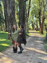 Poncho de lana merino color verde oliva, con diseño sin cuello, caída fluida y flecos en todo el ruedo.