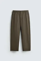 Pantalón regular fit color verde militar, con cintura elástica, bolsillos laterales y detalle de bolsillos traseros de vivo. Cierre frontal con cremallera y botón.