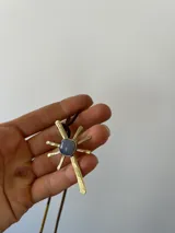 Gargantilla con cordones de gamuza marrón y dije de sol dorado con piedra de ágata en el centro.