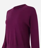 Suéter negro de punto leve, corte boxy, cuello redondo y mangas largas con puños y bajo acanalados.