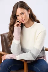 Buzo de tejido de punto con diseño de rayas horizontales en tonos blanco, gris y rosado. Presenta cuello redondo, mangas largas y terminaciones acanaladas en puños y ruedo. Incluye un pequeño aplique de cuero sintético en la parte inferior.