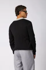 Sweater de punto acanalado en color negro, con cuello polo en contraste color crema. Presenta detalles bordados en el pecho y estampado tipográfico central con la frase 'Concept ALL GOOD FEELS'.