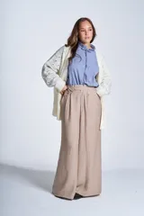 Sacón de hilado frizado color crudo, con calado delicado y bolsillos tejidos al frente. De corte relajado.