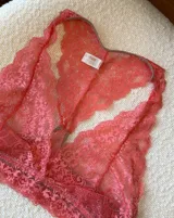 Soutien tipo bralette negro de encaje con diseño floral, espalda estilo nadador y elástico en el bajo busto para sujeción.