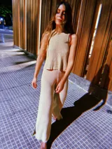 Blusa de punto color beige con lurex, modelo halter y diseño acanalado.